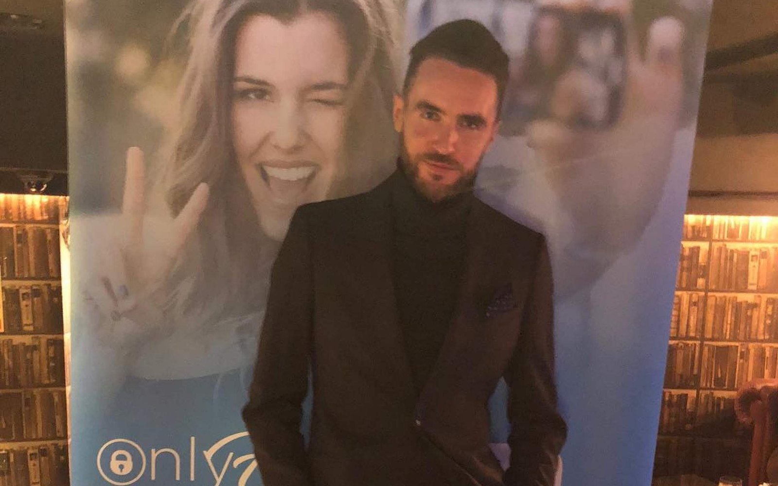 Мужчина перед одним из первых баннеров OnlyFans на отраслевом мероприятии